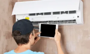 uomo che installa un condizionatore nella propria casa senza esperienza seguendo solo istruzioni